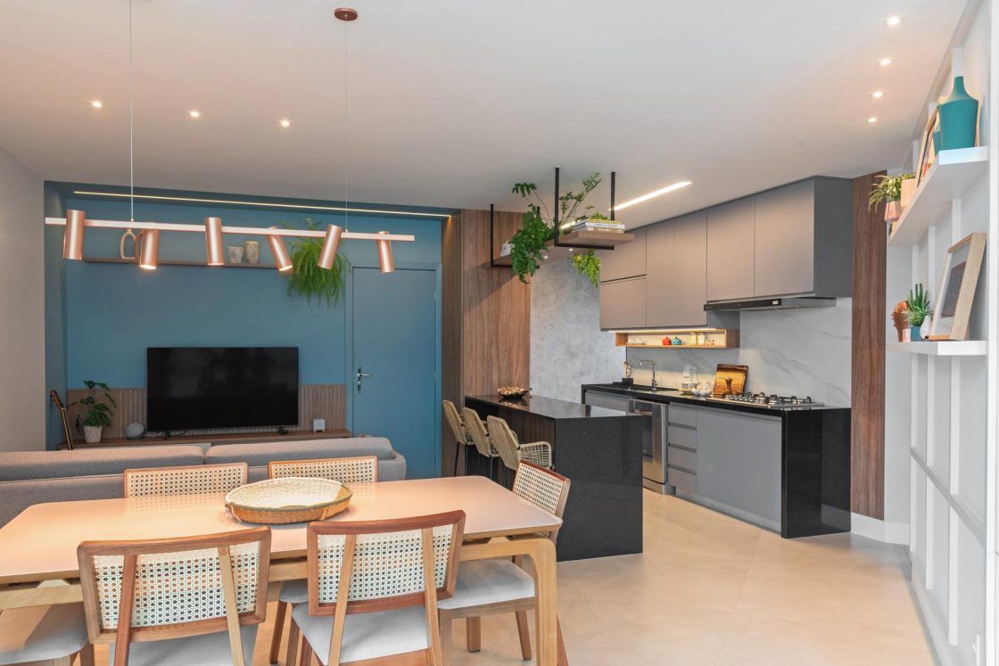 Cozinha funcional e bonita com armários planejados, iluminação moderna e integração com sala de jantar