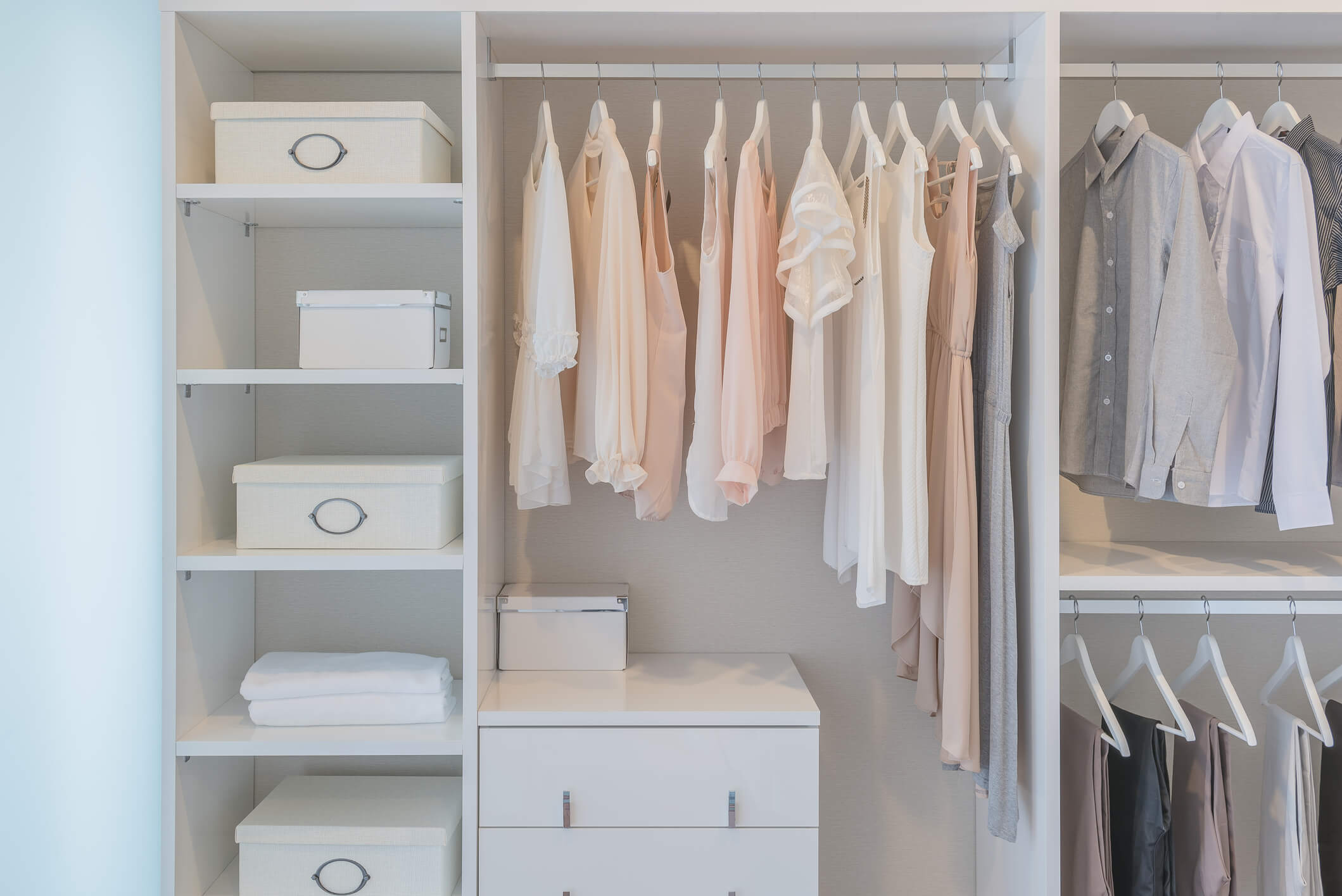 "Guarda-roupa organizado com roupas penduradas por cor e caixas etiquetadas"